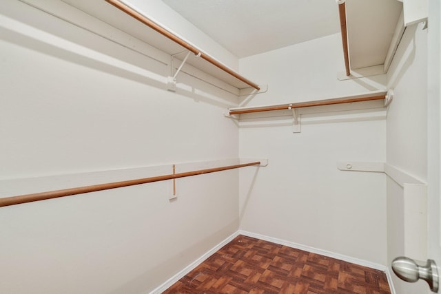 spacious closet with dark parquet flooring