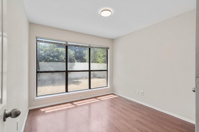 unfurnished room with hardwood / wood-style floors