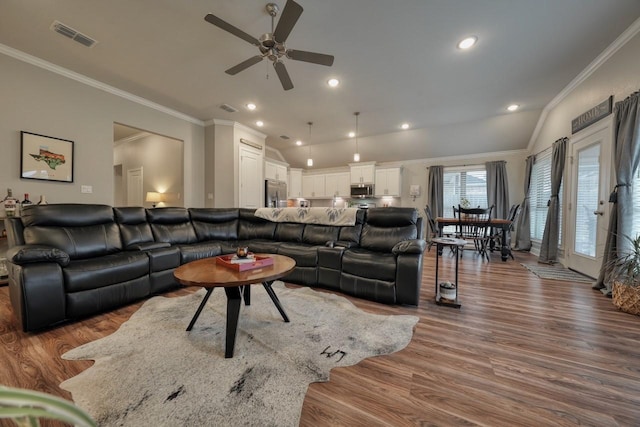 living room with hardwood / wood-style flooring, ornamental molding, lofted ceiling, and ceiling fan