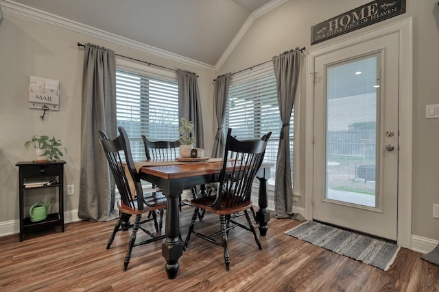 dining space with vaulted ceiling, ornamental molding, and wood-type flooring