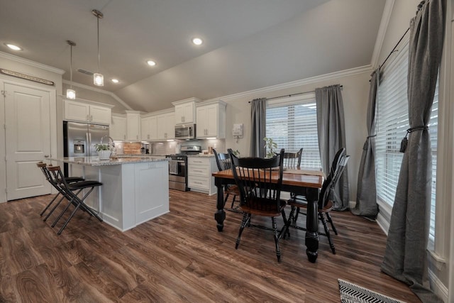 kitchen featuring pendant lighting, white cabinetry, a breakfast bar area, a center island, and stainless steel appliances