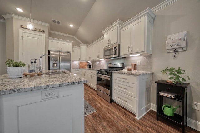 kitchen featuring white cabinetry, ornamental molding, light stone countertops, and appliances with stainless steel finishes