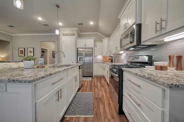 kitchen featuring sink, stainless steel appliances, an island with sink, white cabinets, and decorative light fixtures