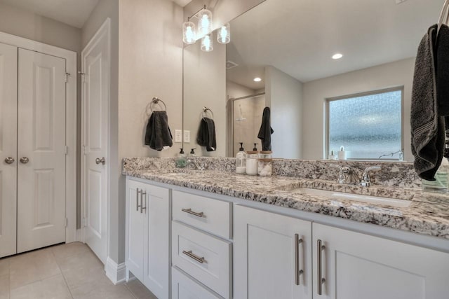 bathroom featuring vanity, a shower with shower door, and tile patterned flooring