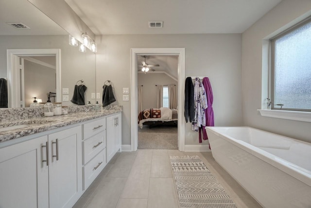 bathroom with a tub to relax in, vanity, and vaulted ceiling