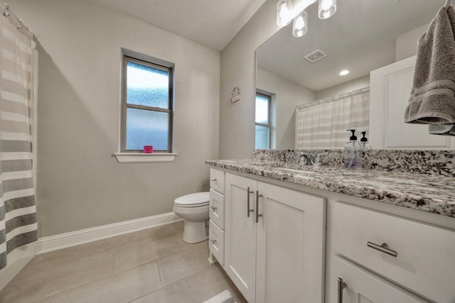 bathroom with tile patterned floors, plenty of natural light, toilet, and vanity