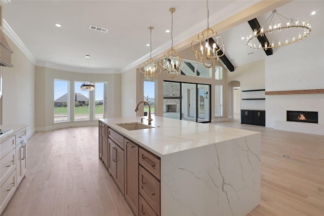 121 Ford Ct, Weston, TX 75009 - kitchen featuring a chandelier, a warm lit fireplace, a sink, open floor plan, and light wood-style flooring
