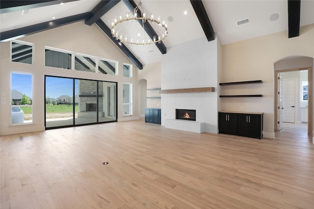 121 Ford Ct, Weston, TX 75009 - unfurnished living room featuring arched walkways, high vaulted ceiling, beamed ceiling, light wood-style flooring, and a chandelier