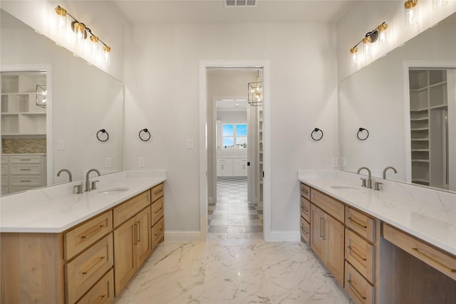 121 Ford Ct, Weston, TX 75009 - bathroom with two vanities, baseboards, a walk in closet, and marble finish flooring