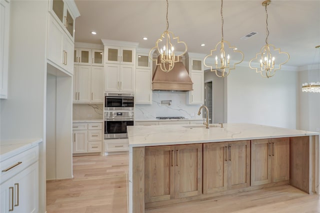 121 Ford Ct, Weston, TX 75009 - kitchen with stainless steel double oven, a chandelier, tasteful backsplash, light wood-type flooring, and black gas stovetop