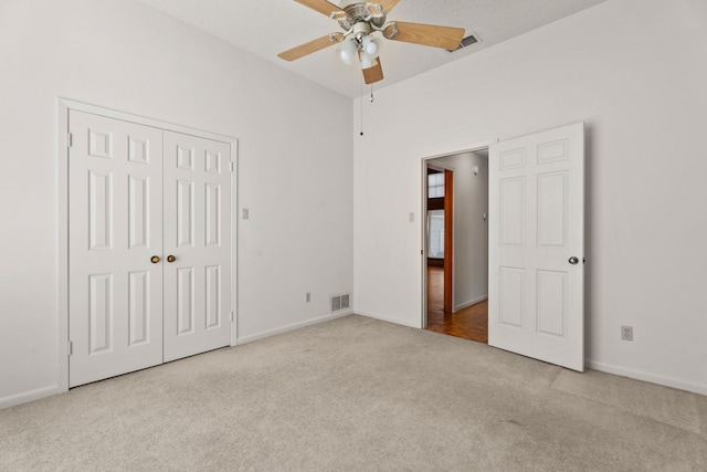 unfurnished bedroom with ceiling fan, a closet, and light carpet