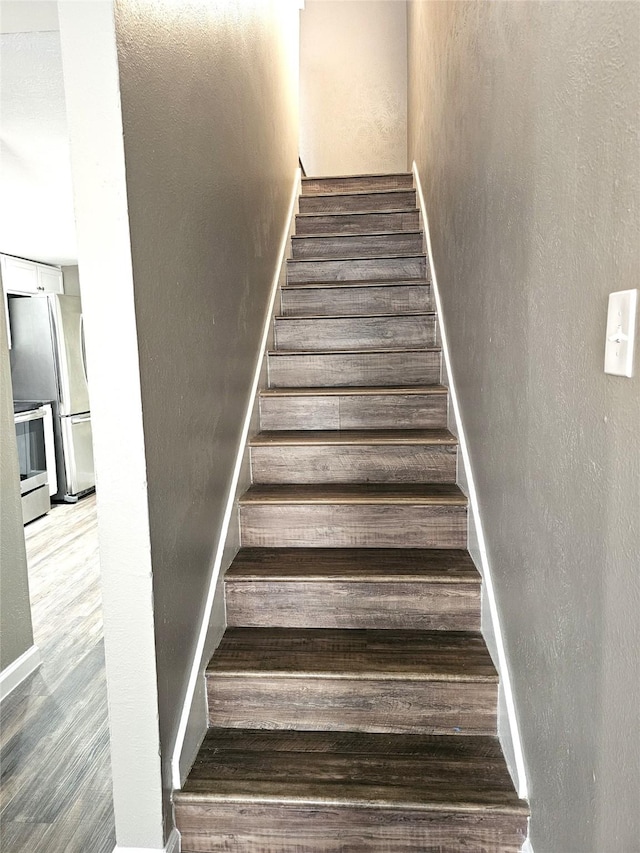 staircase with hardwood / wood-style floors