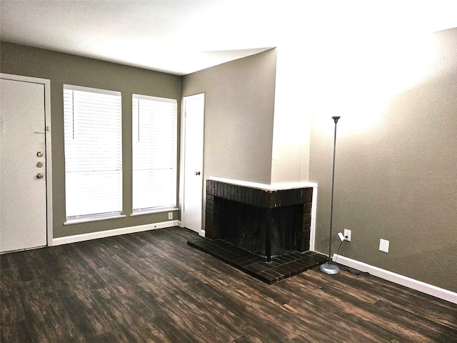 unfurnished living room with a fireplace and dark hardwood / wood-style flooring