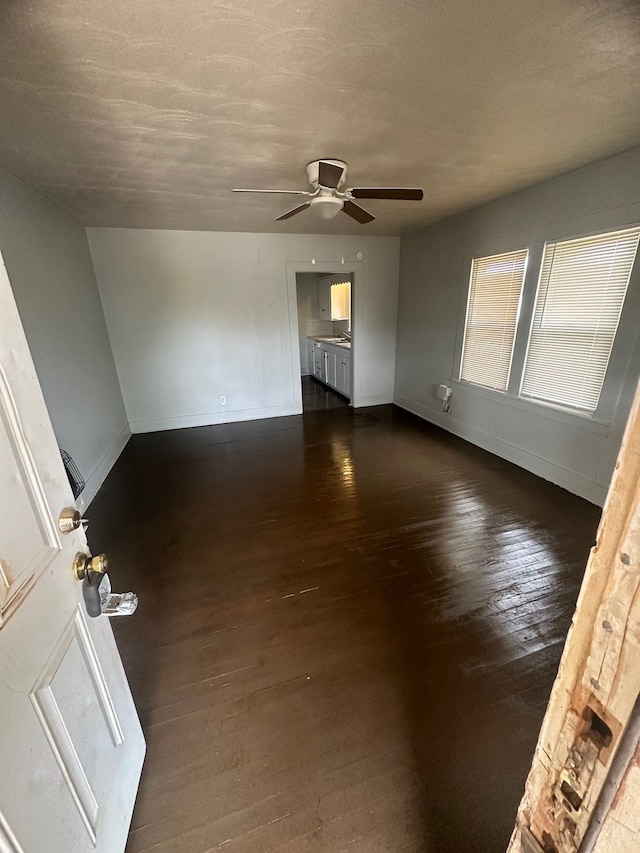 unfurnished room with dark hardwood / wood-style flooring, a textured ceiling, and ceiling fan