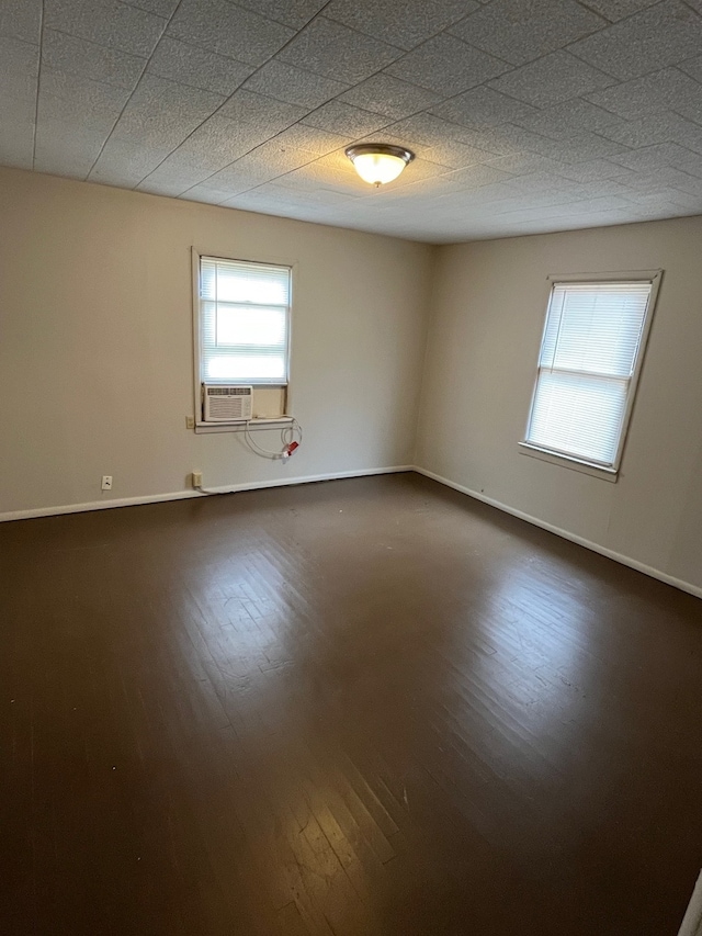 unfurnished room featuring dark hardwood / wood-style flooring and a textured ceiling