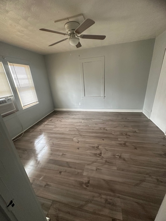 spare room with ceiling fan, cooling unit, a textured ceiling, and dark hardwood / wood-style flooring