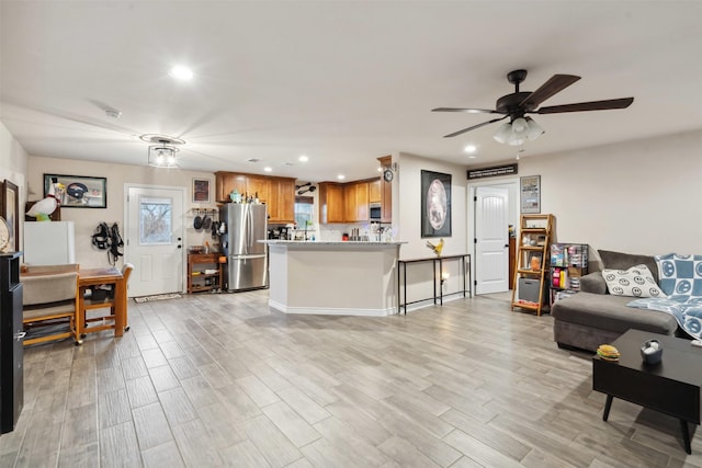 living room featuring ceiling fan and light wood-type flooring