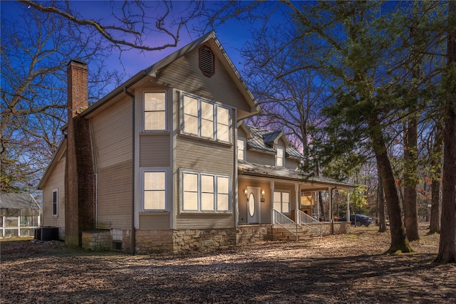 exterior space with a porch, metal roof, and a chimney