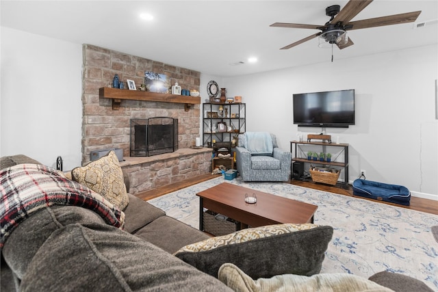 living room featuring hardwood / wood-style floors, a fireplace, and ceiling fan