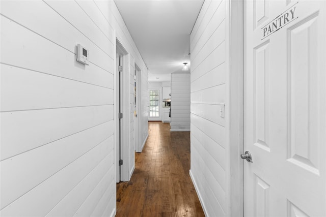 hall featuring dark hardwood / wood-style flooring and wood walls