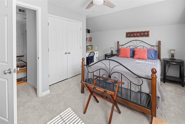 carpeted bedroom with ceiling fan, vaulted ceiling, and a closet