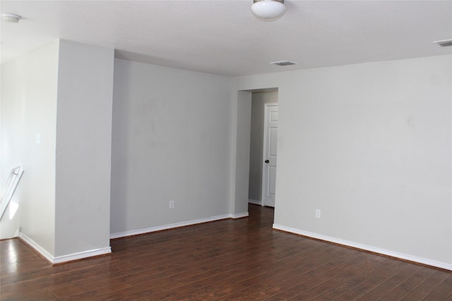 empty room with dark hardwood / wood-style flooring