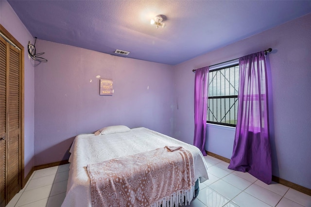 bedroom featuring light tile patterned floors and a closet