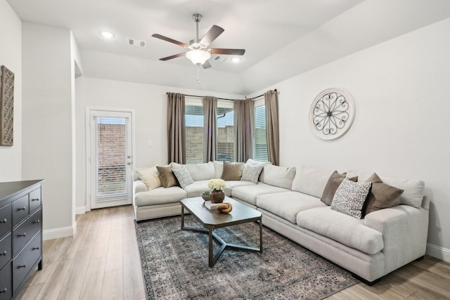 living room with visible vents, ceiling fan, light wood-style flooring, and baseboards