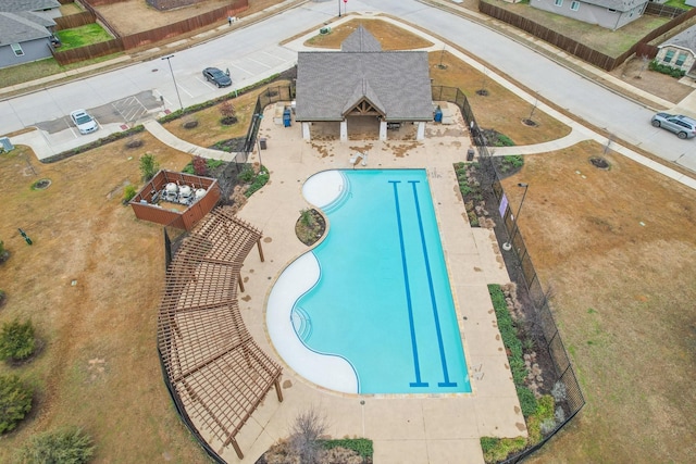 pool with a patio area and fence