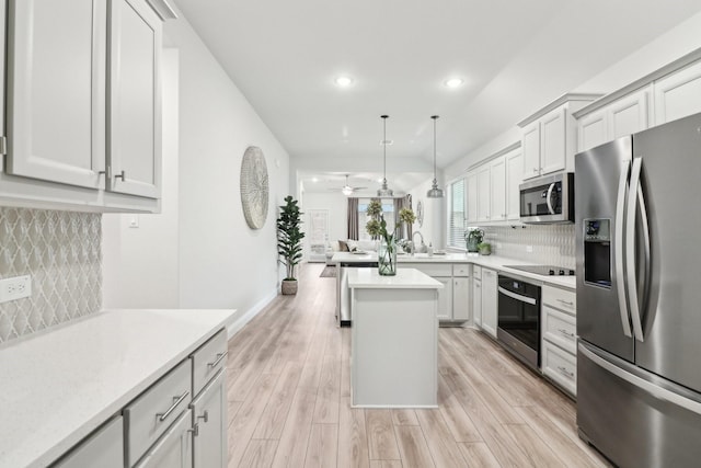 kitchen featuring tasteful backsplash, pendant lighting, stainless steel appliances, and light countertops