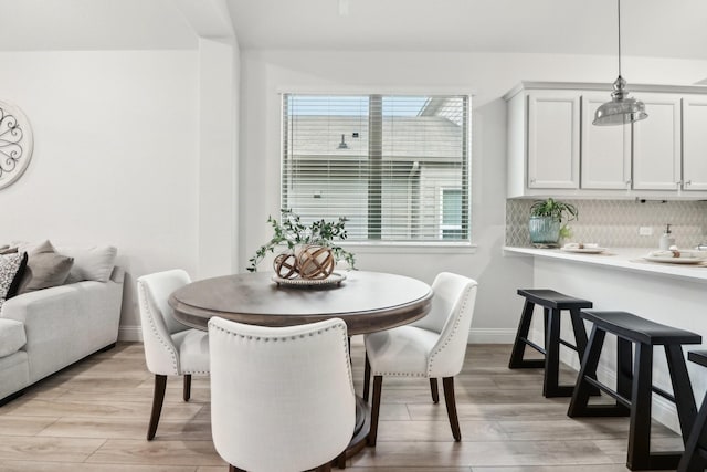 dining room featuring light wood-style flooring and baseboards