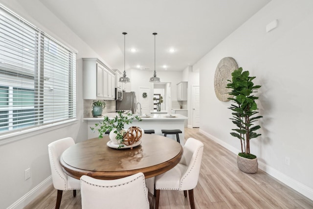 dining area with recessed lighting, light wood-style flooring, and baseboards