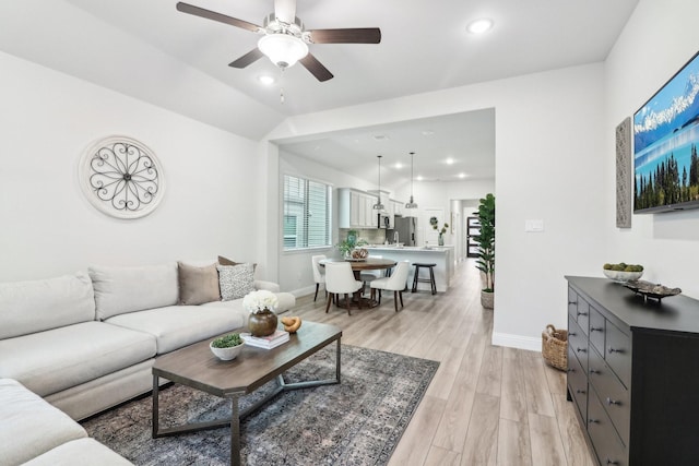 living room with lofted ceiling, recessed lighting, a ceiling fan, light wood-type flooring, and baseboards