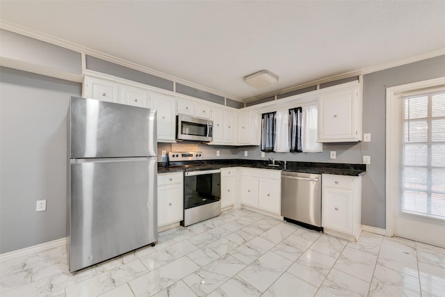 kitchen featuring appliances with stainless steel finishes, dark countertops, marble finish floor, and white cabinetry