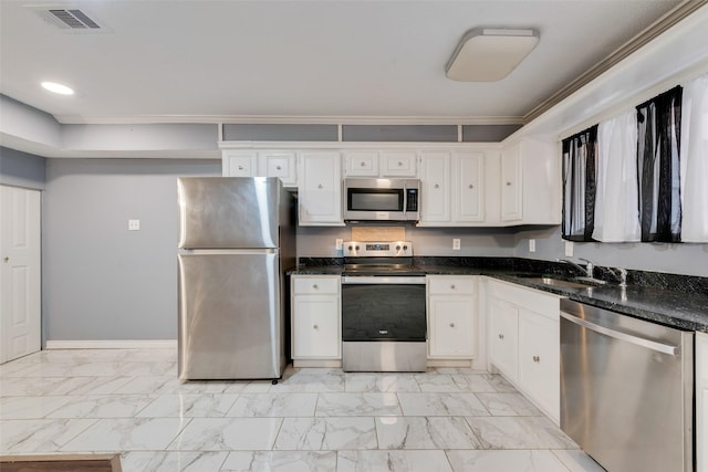 kitchen featuring appliances with stainless steel finishes, marble finish floor, visible vents, and white cabinetry