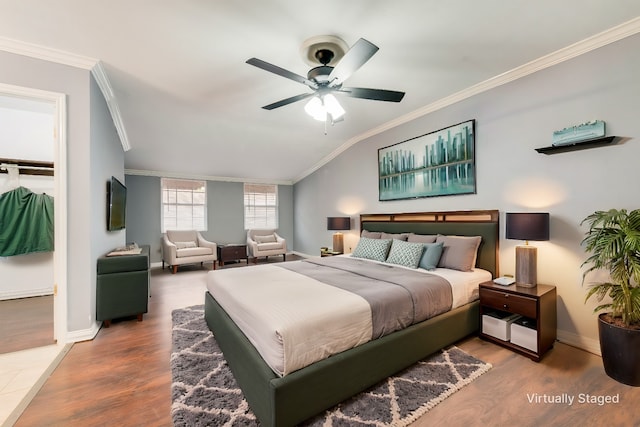 bedroom featuring lofted ceiling, baseboards, crown molding, and wood finished floors