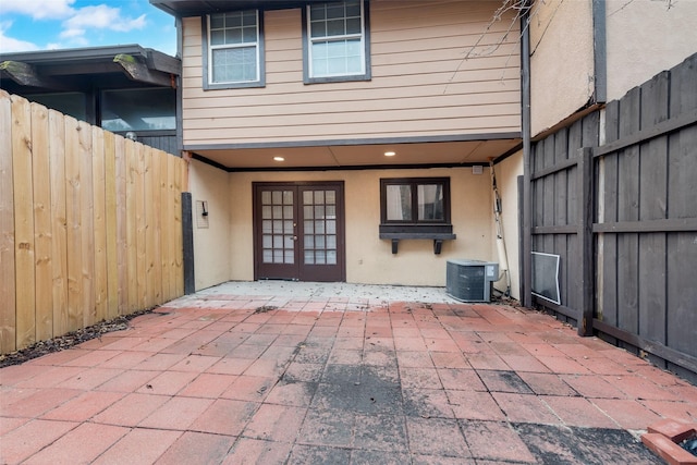 exterior space with a patio area, stucco siding, cooling unit, and fence