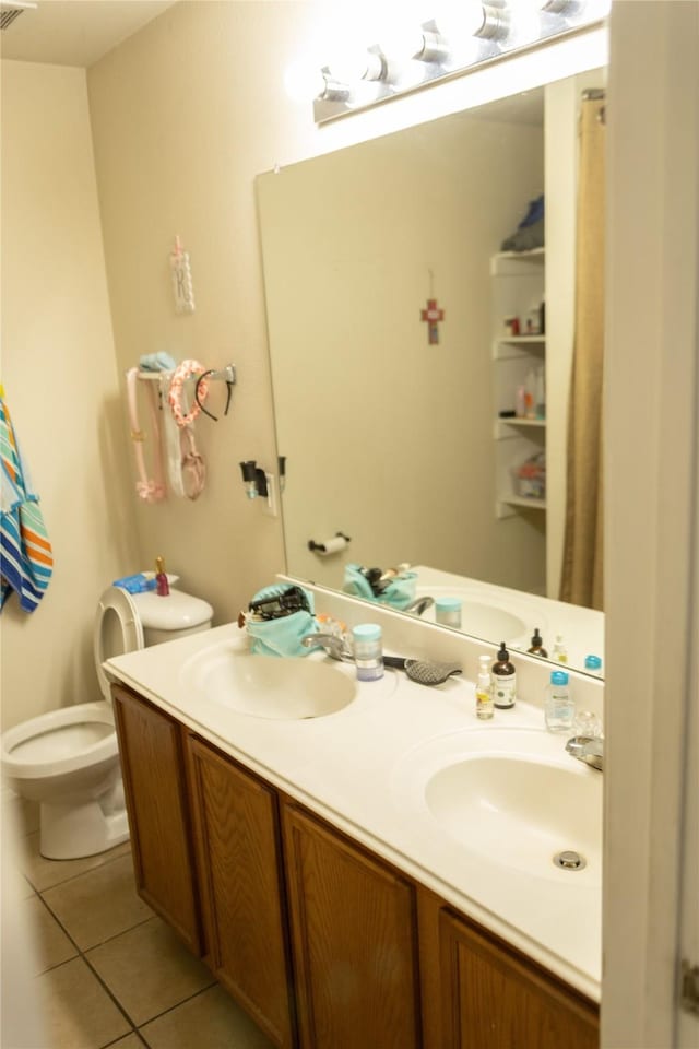 bathroom with tile patterned flooring, vanity, and toilet