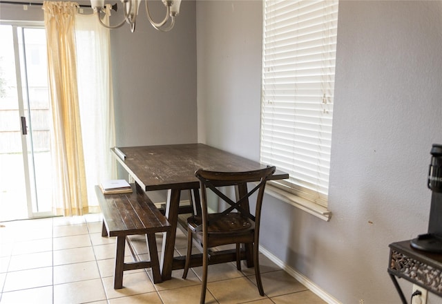 dining area featuring light tile patterned floors and an inviting chandelier