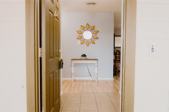 hall featuring light tile patterned floors and visible vents