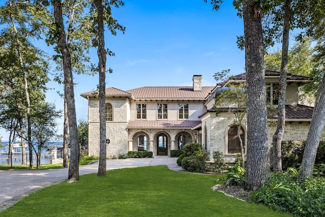 mediterranean / spanish house featuring a front lawn