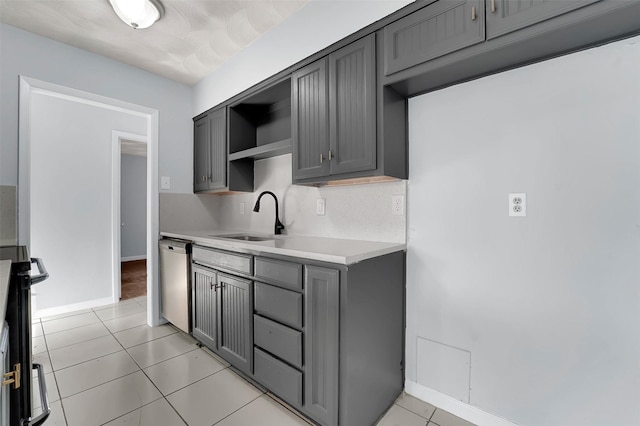 kitchen featuring gray cabinets, electric range oven, dishwasher, sink, and light tile patterned floors