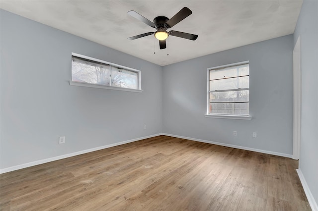 empty room with ceiling fan and light hardwood / wood-style flooring