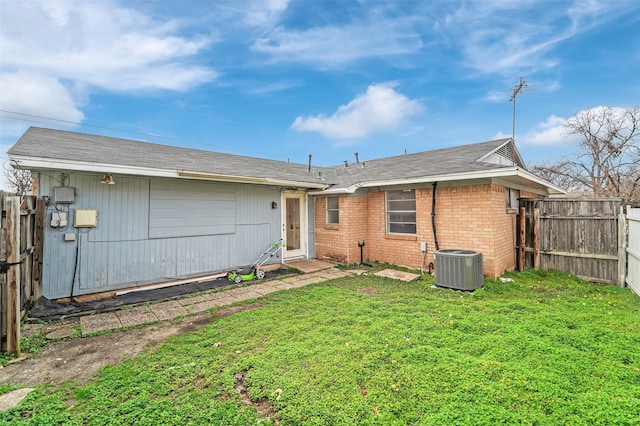 back of property featuring a lawn and central air condition unit