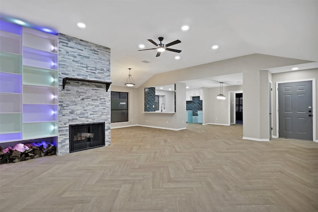 unfurnished living room with lofted ceiling, sink, light parquet floors, ceiling fan, and a stone fireplace