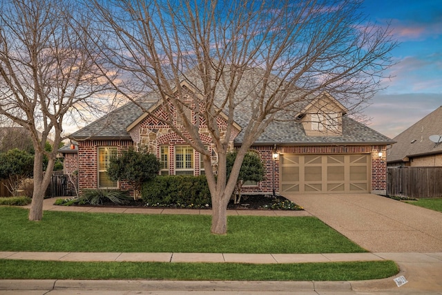 tudor-style house with a garage and a lawn