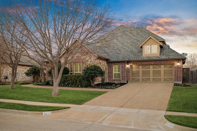 view of front of property with a yard and a garage