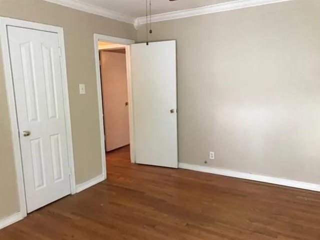 unfurnished bedroom featuring dark hardwood / wood-style flooring and ornamental molding