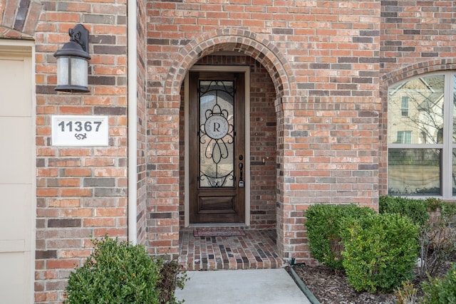 view of exterior entry featuring brick siding