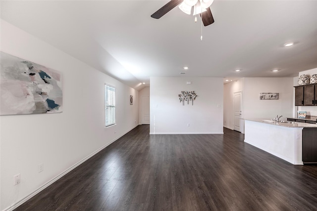 unfurnished living room featuring sink, dark wood-type flooring, and ceiling fan